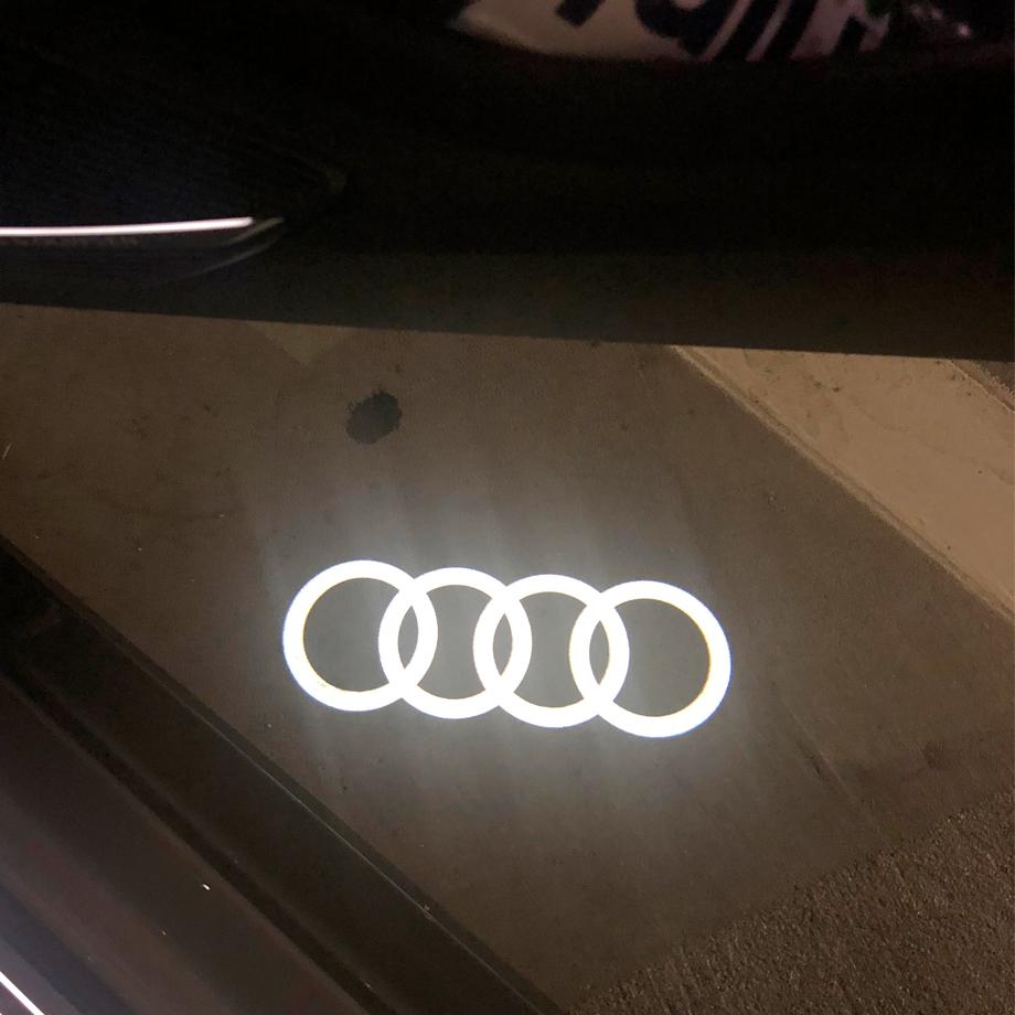 My real Audi rings next to fake Audi rings puddle light. - AudiWorld Forums